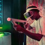 An adult enjoys virtual reality gaming with neon lighting and modern equipment.